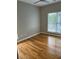 A bedroom with hardwood floors, neutral walls, a ceiling fan, and a bright window overlooking the outside at 1651 Massachusetts Sw Ave # 1, Marietta, GA 30008