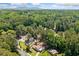 Expansive aerial view of a home surrounded by lush greenery and mature trees with a distant view of mountain at 3050 Woodland Nw Dr, Kennesaw, GA 30152