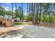 Spacious backyard with mature trees and partially fenced yard and large concrete patio at 3050 Woodland Nw Dr, Kennesaw, GA 30152