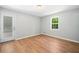 Bright bedroom featuring sleek, new hardwood flooring, fresh paint, and natural light from the exterior door at 3050 Woodland Nw Dr, Kennesaw, GA 30152