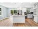 Bright kitchen featuring white cabinets, stainless steel appliances, a granite island, and sliding doors to the deck at 3050 Woodland Nw Dr, Kennesaw, GA 30152
