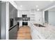 Modern kitchen featuring white cabinets, stainless steel appliances, granite counters, and an island at 3050 Woodland Nw Dr, Kennesaw, GA 30152