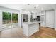 Open kitchen with white cabinets, a large island with granite countertops, stainless steel appliances, and backyard views at 3050 Woodland Nw Dr, Kennesaw, GA 30152
