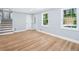 Open-concept living room with hardwood floors, a staircase, and large windows providing natural light at 3050 Woodland Nw Dr, Kennesaw, GA 30152