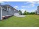 Expansive backyard showcasing a well-maintained lawn, flower beds, and a three-car garage at 4035 Pinebrook Cir, Cumming, GA 30028