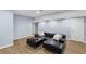 Finished basement with light blue walls, wood floors, and a black sectional sofa with an ottoman at 4035 Pinebrook Cir, Cumming, GA 30028