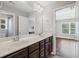 This bathroom features double sinks, wood cabinetry, and a view into the bedroom at 4035 Pinebrook Cir, Cumming, GA 30028