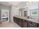 Main bathroom with dual sinks, granite countertops, and a view into the bedroom at 4035 Pinebrook Cir, Cumming, GA 30028