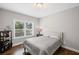 Bright bedroom featuring hardwood floors and a large window offering an outdoor view at 4035 Pinebrook Cir, Cumming, GA 30028