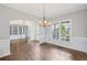 Formal dining room with beautiful hardwood floors, wainscoting, and a stylish chandelier at 4035 Pinebrook Cir, Cumming, GA 30028