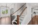 Inviting foyer features a staircase with wood handrail and a glimpse of the kitchen and front door at 4035 Pinebrook Cir, Cumming, GA 30028
