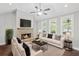 Cozy living room with a stone fireplace, a ceiling fan and plenty of natural light from surrounding windows at 4035 Pinebrook Cir, Cumming, GA 30028