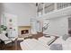 Bright living room with stone fireplace, built-in shelving, hardwood floors and white leather furniture at 4035 Pinebrook Cir, Cumming, GA 30028