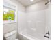 Bright bathroom features a tub/shower combo with a large window bringing natural light and serene outdoor views at 4093 Groveland Park Dr, Powder Springs, GA 30127