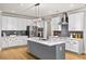 Kitchen with white cabinets, stainless steel appliances, an island, and modern lighting at 4093 Groveland Park Dr, Powder Springs, GA 30127