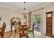 Dining room with chandelier, wood table, and sliding door to the porch at 139 Lake Reserve Way, Canton, GA 30115