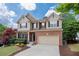 Attractive two-story home featuring a brick and siding exterior, mature trees, and a two-car garage at 139 Lake Reserve Way, Canton, GA 30115