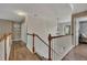Upstairs hallway with hardwood floors, decorative light fixture, and view into bedroom at 139 Lake Reserve Way, Canton, GA 30115