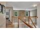 Upstairs hallway featuring hardwood floors, stone wall, and windows with natural light at 139 Lake Reserve Way, Canton, GA 30115