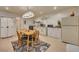 A quaint kitchen area featuring a dining table, appliances, white cabinets, and tile flooring at 139 Lake Reserve Way, Canton, GA 30115