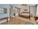 Bright main bedroom featuring hardwood floors, four poster bed, and ensuite bathroom at 139 Lake Reserve Way, Canton, GA 30115