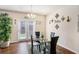 Modern dining area featuring a glass table, four chairs, unique lighting, and doors to outside area at 1907 Sea Oats Dr, Hampton, GA 30228