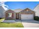 Charming single-story home with brick facade, attached garage, manicured lawn and vibrant red window shutters at 1907 Sea Oats Dr, Hampton, GA 30228