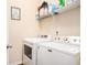 Bright laundry area with modern washer and dryer, plus practical shelving for storage at 1907 Sea Oats Dr, Hampton, GA 30228