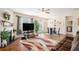 Cozy living room featuring a fireplace, decorative rug, hardwood floors, dining set and large windows at 1907 Sea Oats Dr, Hampton, GA 30228