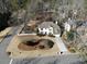 Aerial view of a property featuring a well-maintained lawn, mature trees, and a long driveway at 5440 Cameron Forest Pkwy, Johns Creek, GA 30022