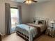Cozy bedroom featuring a bed with decorative pillows, a window with curtains, and a side table at 5440 Cameron Forest Pkwy, Johns Creek, GA 30022