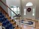 Grand foyer featuring a hardwood floor, elegant staircase with a decorative runner, and a decorative glass door at 5440 Cameron Forest Pkwy, Johns Creek, GA 30022