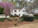 Charming two-story home with white picket fence and mature landscaping, including a beautiful flowering tree at 5440 Cameron Forest Pkwy, Johns Creek, GA 30022