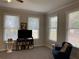 Living room featuring carpet, tv, bookshelves, and natural light at 5440 Cameron Forest Pkwy, Johns Creek, GA 30022