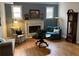 Cozy living room with fireplace, grandfather clock, wood floors, and lots of natural light at 5440 Cameron Forest Pkwy, Johns Creek, GA 30022