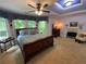 Spacious bedroom with a tray ceiling, fireplace, and large windows with decorative valances at 5440 Cameron Forest Pkwy, Johns Creek, GA 30022