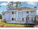 Spacious backyard with a light blue home featuring a deck, many windows, and privacy fence at 771 James Cir, Lawrenceville, GA 30046