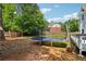 View of the backyard with a trampoline next to a wood deck overlooking the lawn at 771 James Cir, Lawrenceville, GA 30046