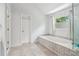 Bright bathroom featuring a soaking tub with mosaic tile surround and a glass-enclosed shower at 771 James Cir, Lawrenceville, GA 30046