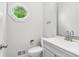 Half bathroom features a octagon window, wall decorations, toilet, and vanity sink at 771 James Cir, Lawrenceville, GA 30046