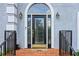 Elegant front door with decorative glass, brick steps, and stylish exterior lighting at 771 James Cir, Lawrenceville, GA 30046