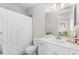 Bright bathroom with white vanity, toilet, shower with curtain, and modern lighting at 250 Castleberry Station Sw Dr, Atlanta, GA 30313