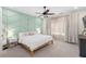 Cozy main bedroom with a chevron accent wall, ceiling fan, plush carpet, and natural light at 250 Castleberry Station Sw Dr, Atlanta, GA 30313