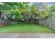 Backyard with mature trees and grass, bordered by a wooden fence at 2682 Arbor Glen Pl., Marietta, GA 30066