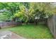 Backyard with mature trees and green grass, bordered by a wooden fence at 2682 Arbor Glen Pl., Marietta, GA 30066