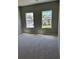 A bedroom with carpet and two windows looking out to other houses at 3708 Cheswolde Ave, Powder Springs, GA 30127