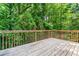 Wooden deck with a wood railing, surrounded by a lush green forest view at 4148 Kings Cswy, Ellenwood, GA 30294