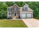 Charming two-story home features a brick and siding exterior with a two-car garage and well-manicured lawn at 4148 Kings Cswy, Ellenwood, GA 30294