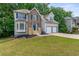 Charming two-story home features a brick and siding exterior with a two-car garage and well-manicured lawn at 4148 Kings Cswy, Ellenwood, GA 30294