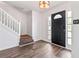 Inviting foyer boasts hardwood floors, a staircase with white railing and a black door with sidelights at 4148 Kings Cswy, Ellenwood, GA 30294